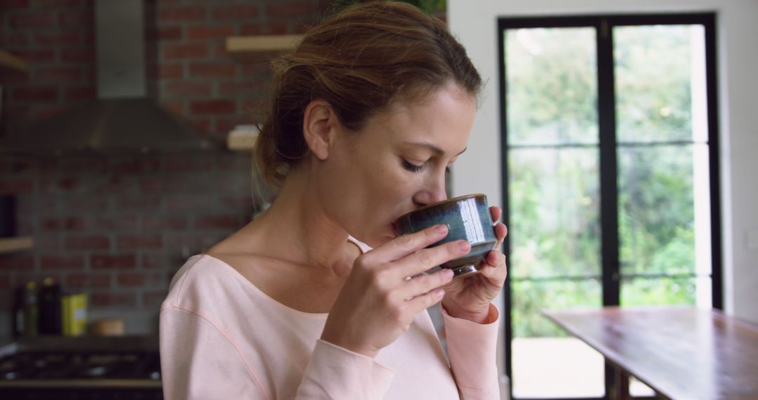 Woman Enjoying Hot Drink in Modern Kitchen - Free Images, Stock Photos and Pictures on Pikwizard.com