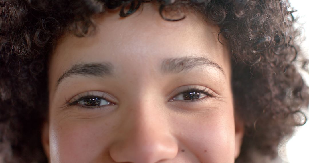 Close-Up of Young Woman with Curly Hair and Warm Smile - Free Images, Stock Photos and Pictures on Pikwizard.com