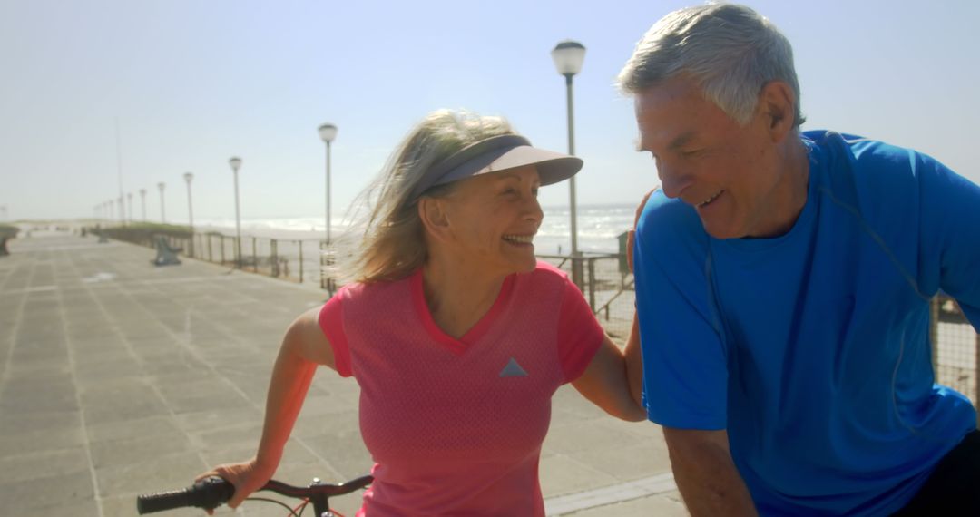 Active Senior Couple Enjoying Beach Promenade with Bicycle