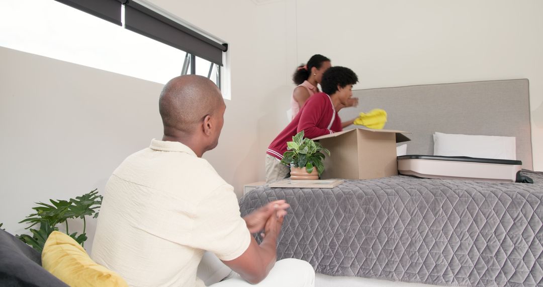 Diverse Family Unpacking Box in New Home