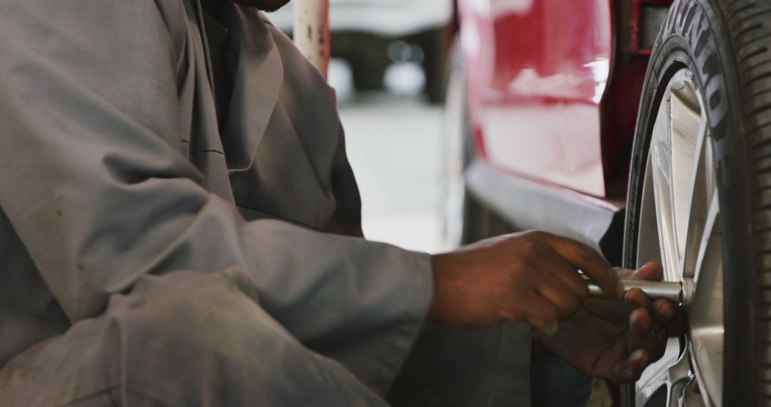 Mechanic Fixing Car Tire in Auto Repair Shop - Free Images, Stock Photos and Pictures on Pikwizard.com