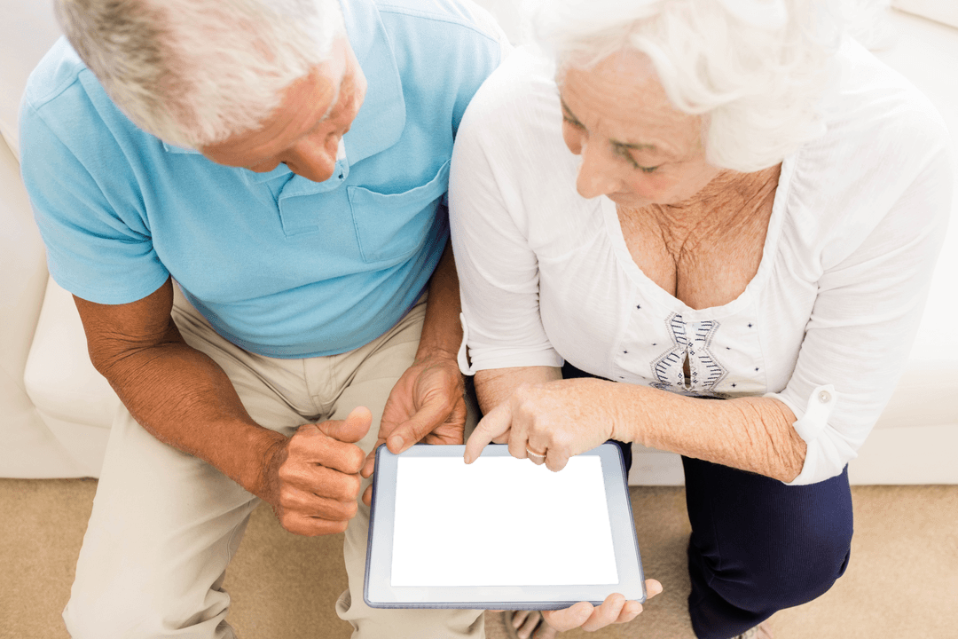 Senior Couple Interacting with Transparent Tablet at Home
