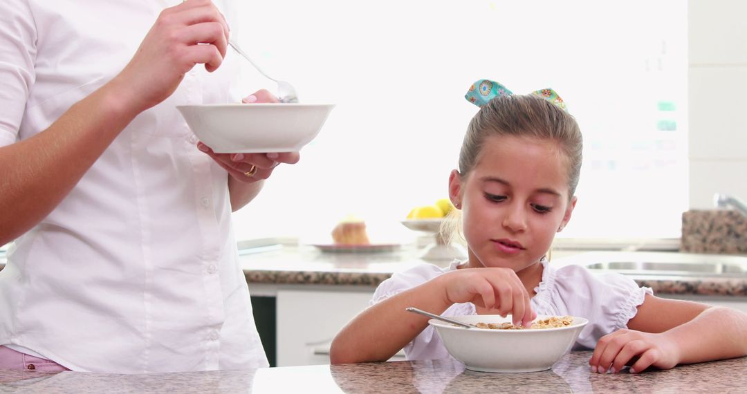 Parent and Child Eating Breakfast Cereal in Modern Kitchen - Free Images, Stock Photos and Pictures on Pikwizard.com