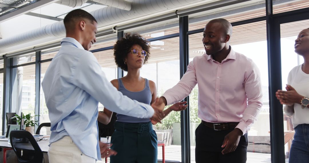 Diverse Team Celebrating Success with Handshake in Office