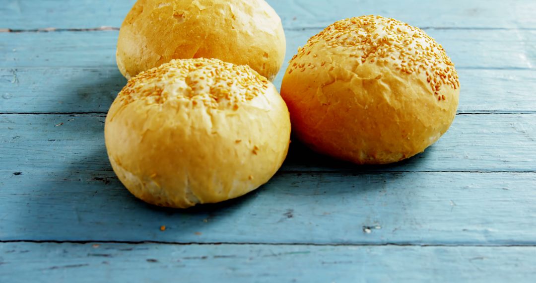 Freshly Baked Round Bread Rolls on Blue Wooden Surface - Free Images, Stock Photos and Pictures on Pikwizard.com