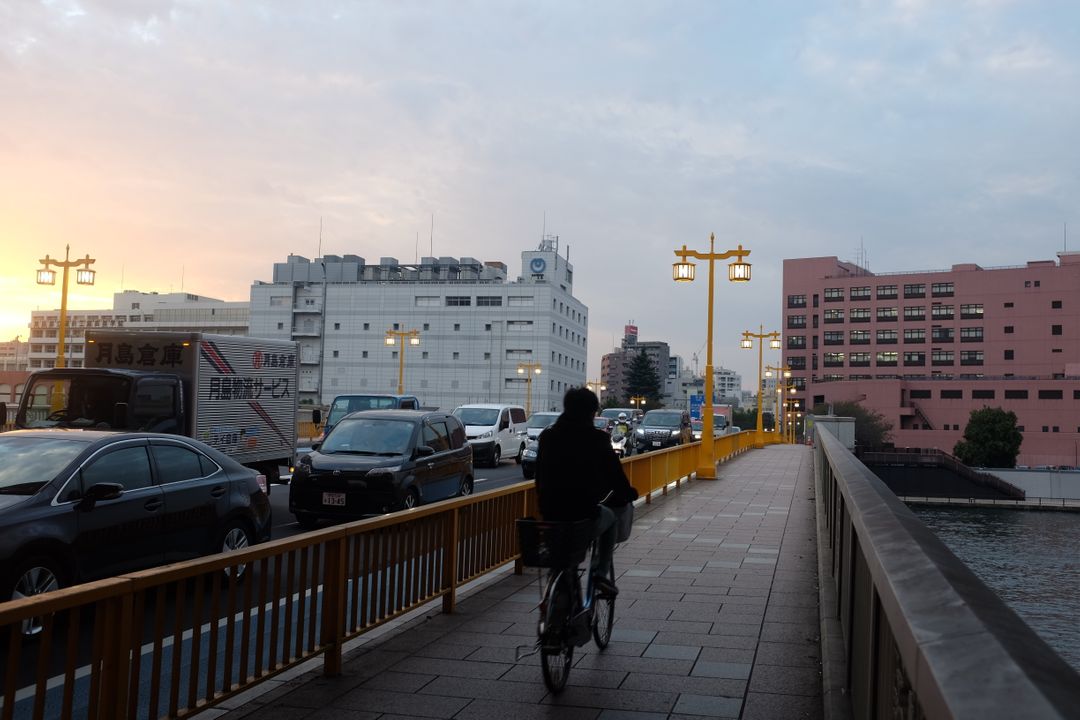 Person Riding Bicycle on Bridgeside Path during Evening Commute - Free Images, Stock Photos and Pictures on Pikwizard.com