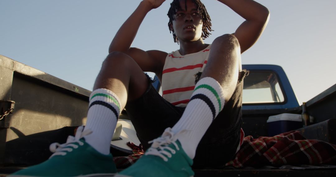 Young Man Relaxing in Pickup Truck at Beach Sunset