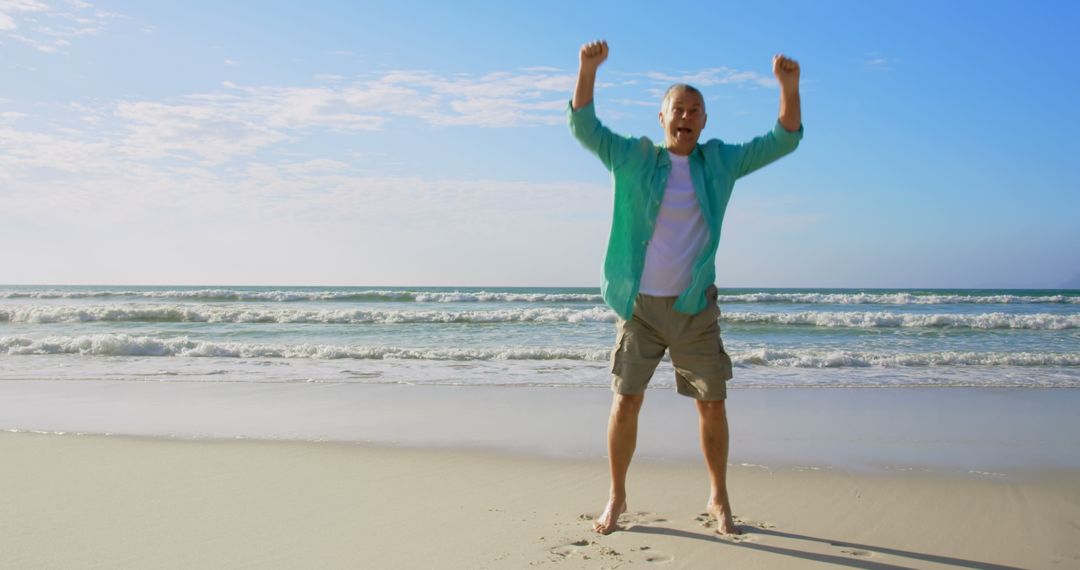 Joyful Senior Man Jumping on Ocean Beach in Sunny Weather
