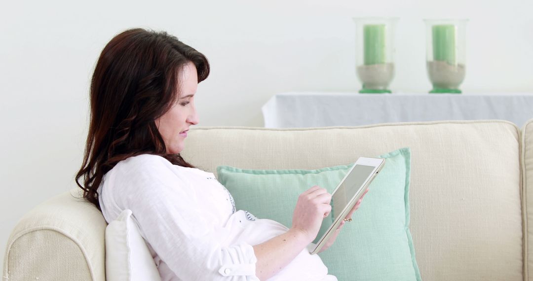 Pregnant Woman Relaxing on Sofa with Digital Tablet - Free Images, Stock Photos and Pictures on Pikwizard.com