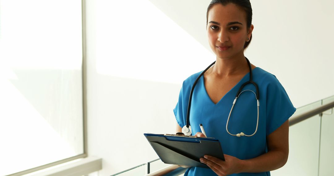 Healthcare Professional Standing with Clipboard and Stethoscope - Free Images, Stock Photos and Pictures on Pikwizard.com