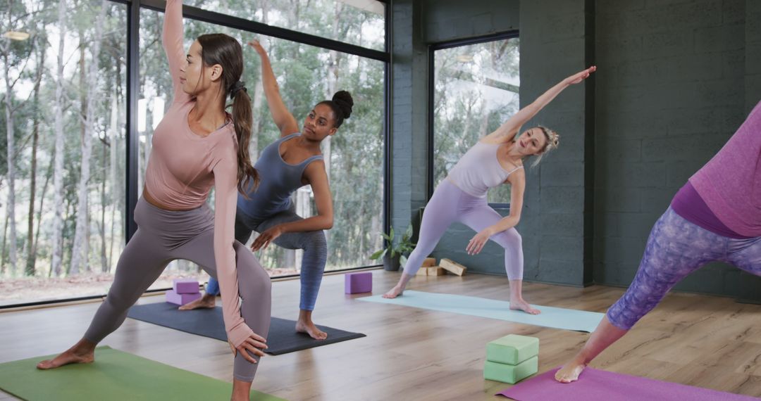 Women Practicing Yoga in Sunlit Studio with Greenery Outside - Free Images, Stock Photos and Pictures on Pikwizard.com