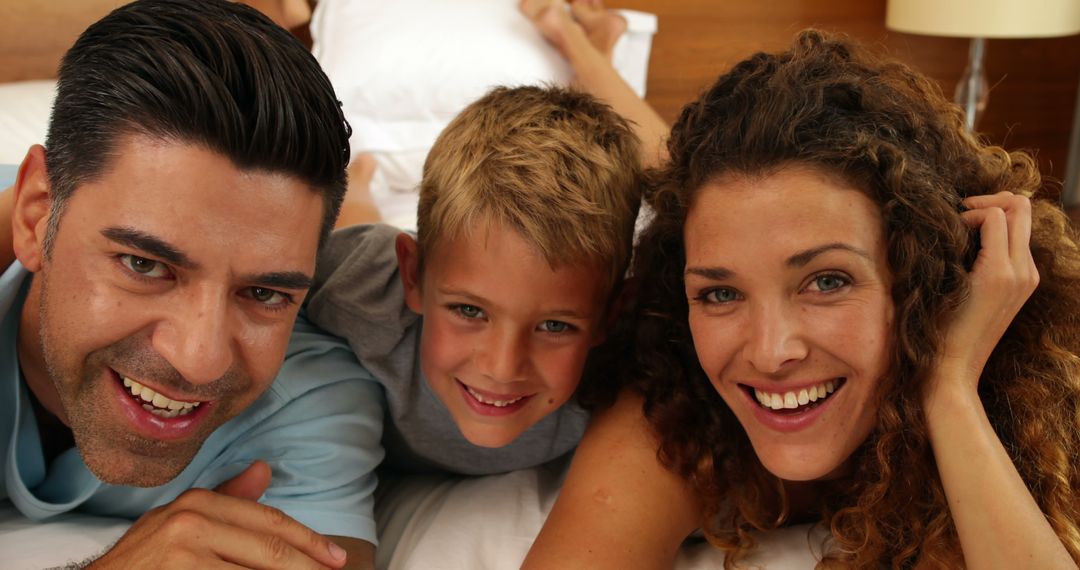 Happy Family Relaxing on Bed with Smiles - Free Images, Stock Photos and Pictures on Pikwizard.com