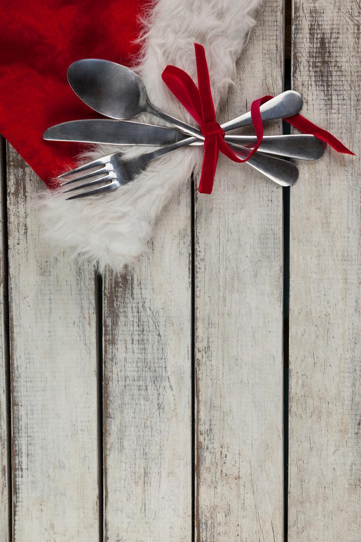 Festive Cutlery Tied with Red Ribbon on Rustic Wooden Board - Free Images, Stock Photos and Pictures on Pikwizard.com