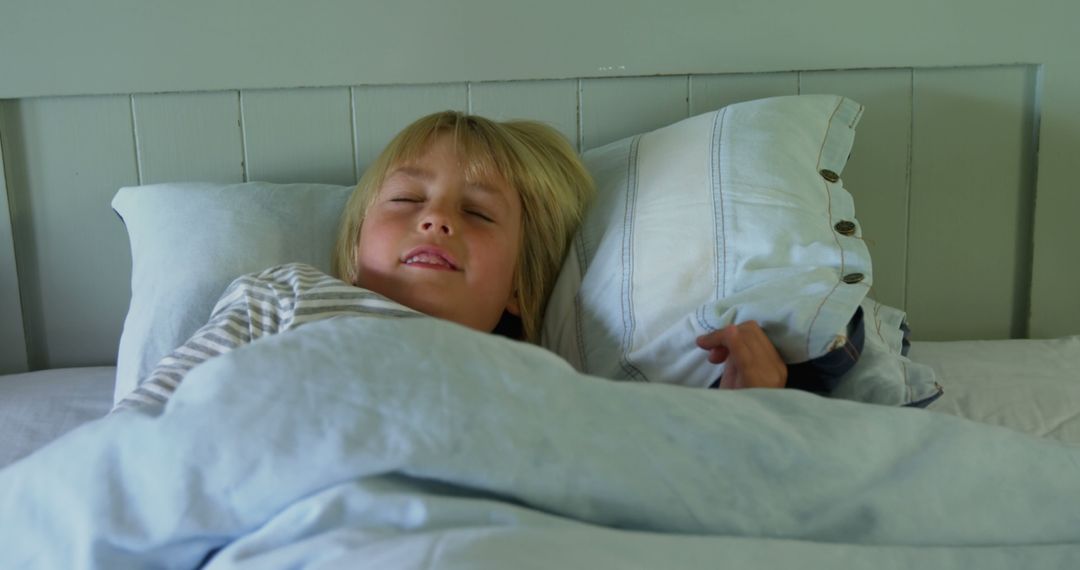 Young Child Smiling While Sleeping in Comfy Bed - Free Images, Stock Photos and Pictures on Pikwizard.com