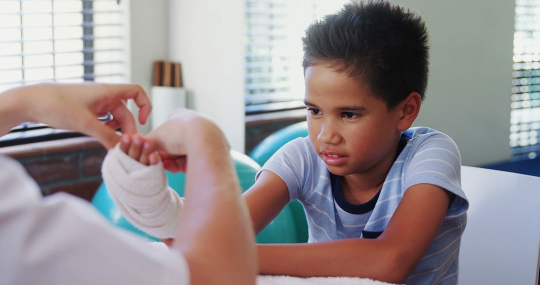 Young Boy Receiving Medical Attention for Bandaged Hand - Free Images, Stock Photos and Pictures on Pikwizard.com