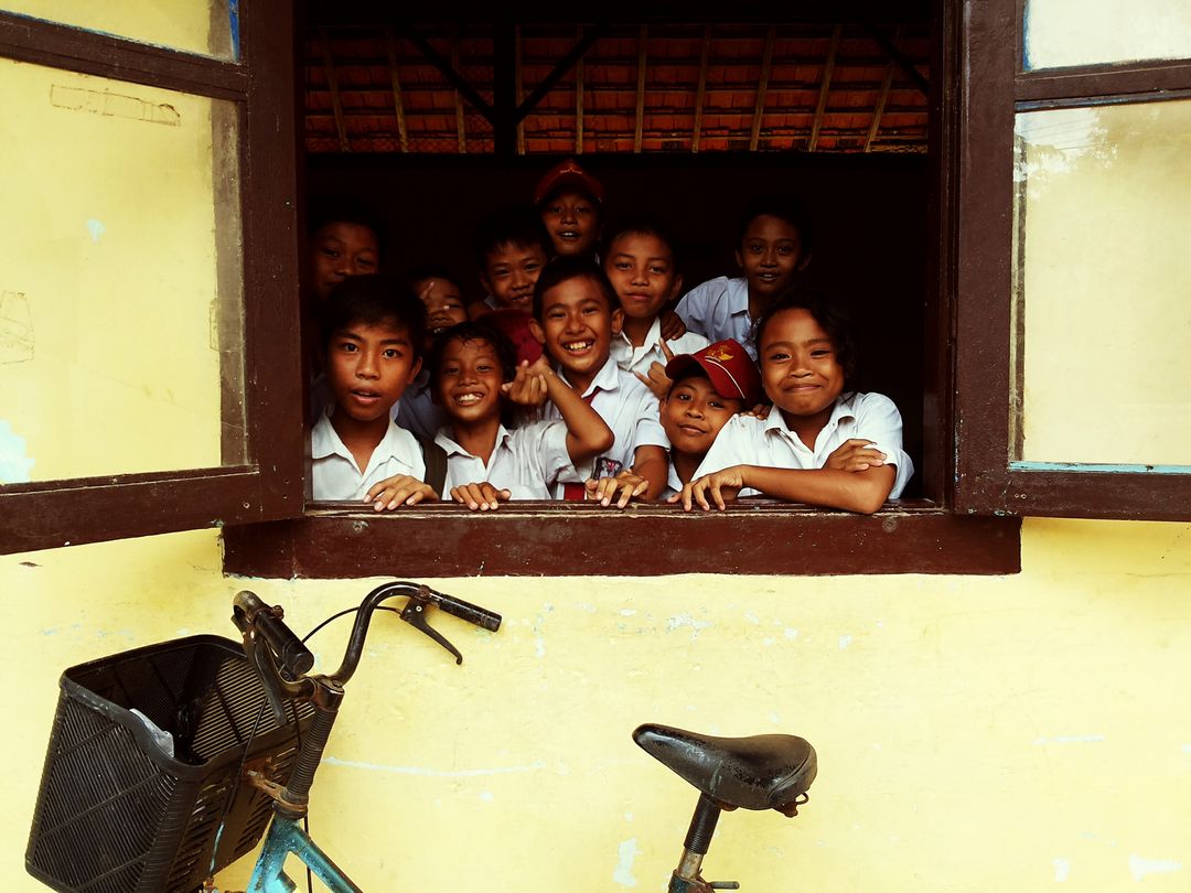 Group of Happy School Children Smiling Through Window
