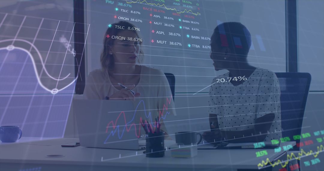 Two Women Discussing Business Trends in Modern Office Setting