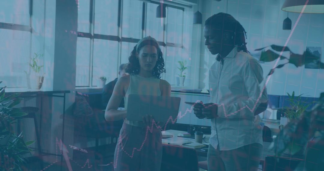 Coworkers Analyzing Data Charts in Modern Open-Plan Office
