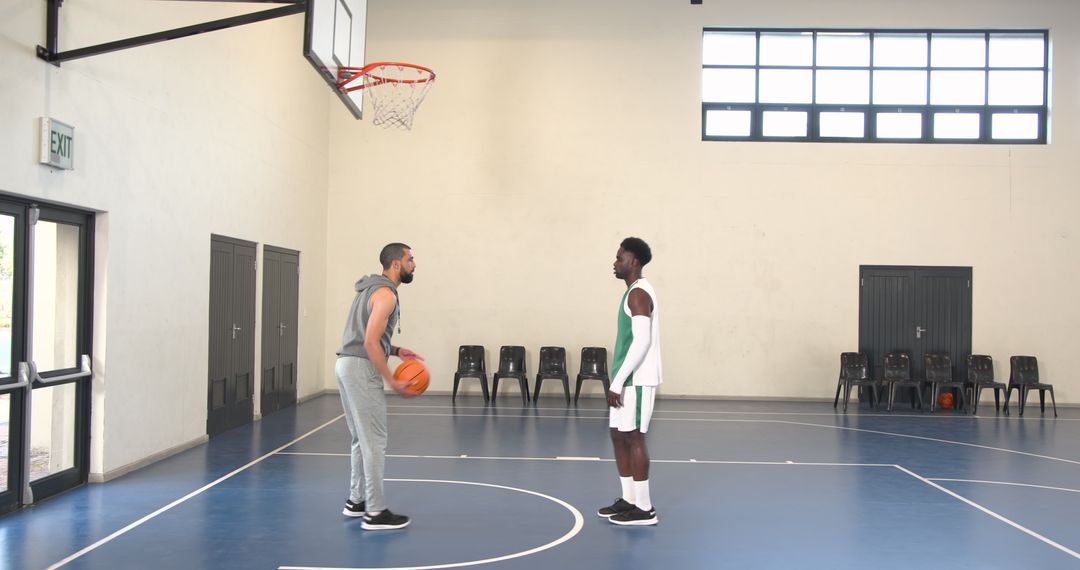 Two Athletes Practicing Basketball in Indoor Gym