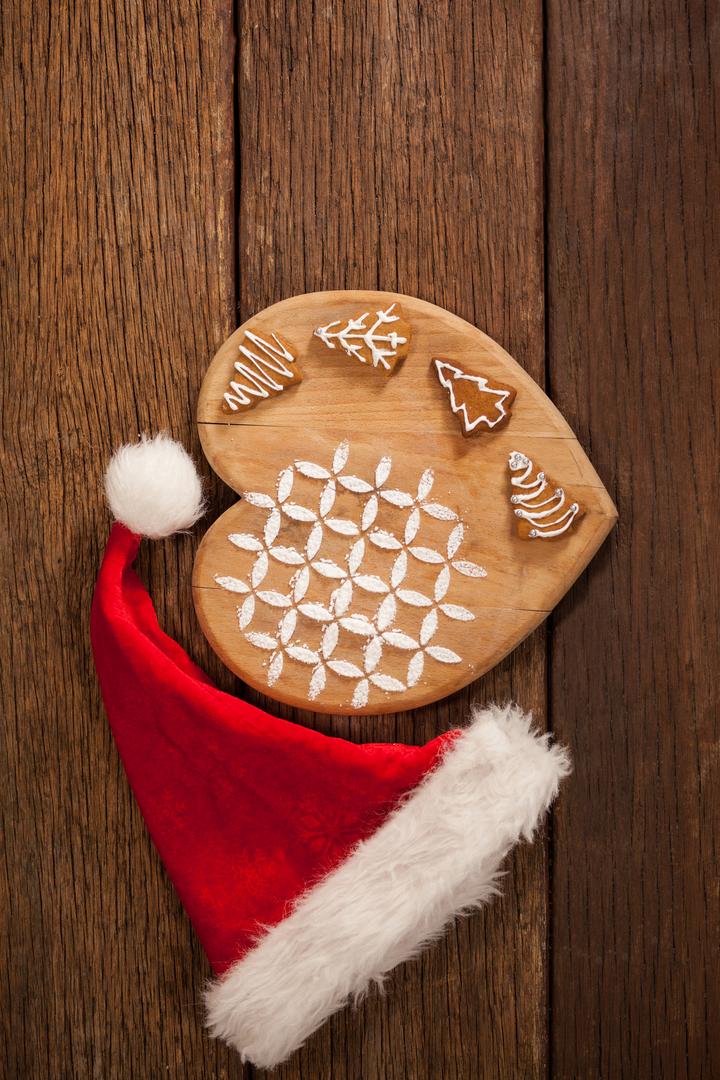 Christmas Gingerbread Cookies with Santa Hat on Wooden Board - Free Images, Stock Photos and Pictures on Pikwizard.com