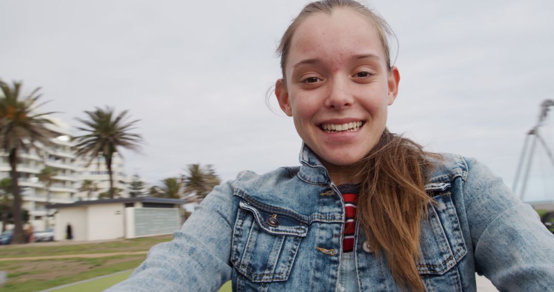 Teenage Girl Smiling Outdoors in Casual Denim Jacket - Free Images, Stock Photos and Pictures on Pikwizard.com