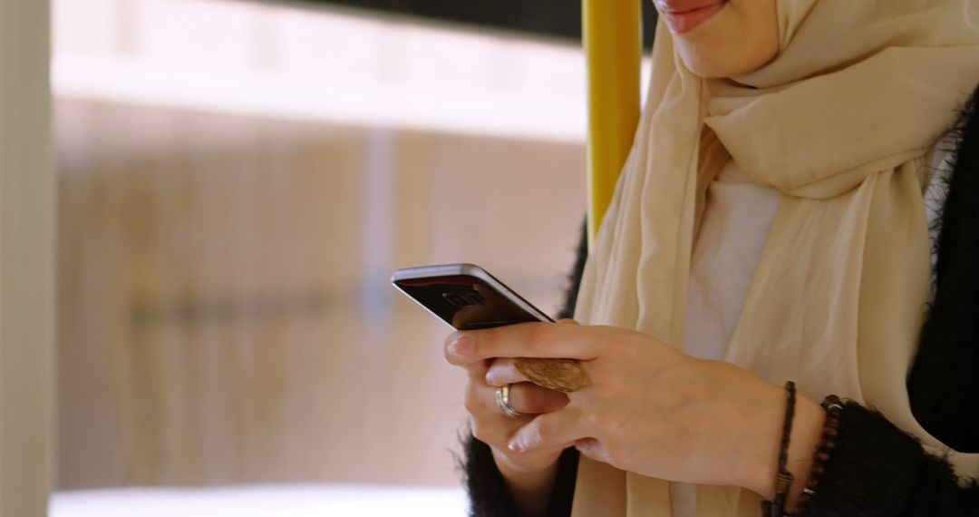 Woman in Hijab Using Smartphone on Public Transportation - Free Images, Stock Photos and Pictures on Pikwizard.com