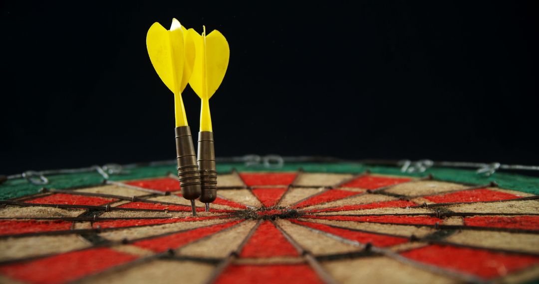 Two yellow darts hitting bullseye on dartboard - Free Images, Stock Photos and Pictures on Pikwizard.com