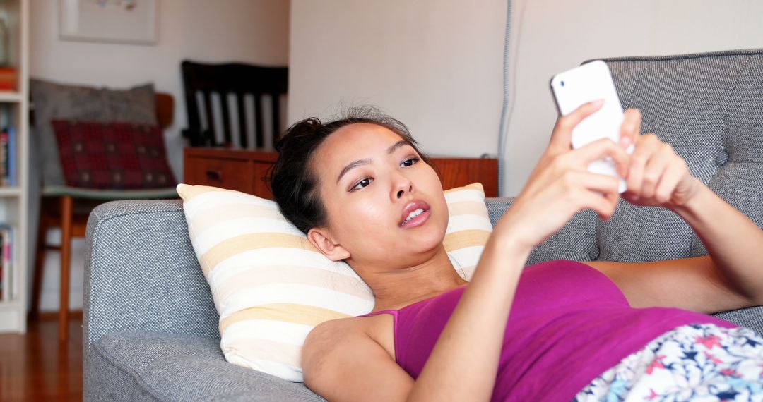 Young Woman Relaxing at Home with Smartphone - Free Images, Stock Photos and Pictures on Pikwizard.com