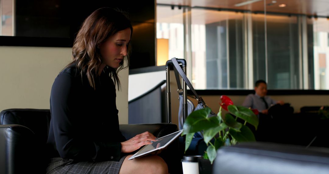 Businesswoman Working on Tablet in Modern Office Lounge - Free Images, Stock Photos and Pictures on Pikwizard.com