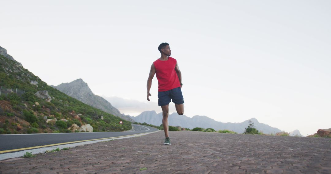 Man Stretching Ready for Morning Run in Mountainous Road - Free Images, Stock Photos and Pictures on Pikwizard.com