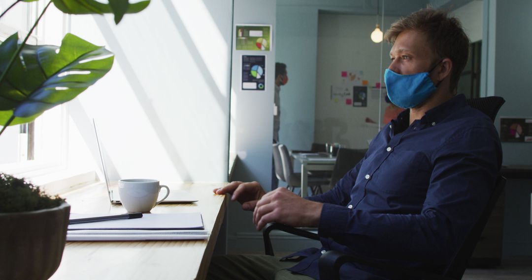 Businessman Wearing Mask Working in Modern Office - Free Images, Stock Photos and Pictures on Pikwizard.com