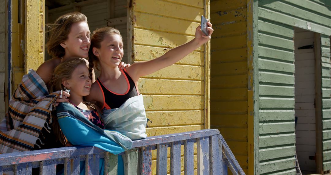 Young Friends Taking Selfie at Beachside Wooden Building - Free Images, Stock Photos and Pictures on Pikwizard.com