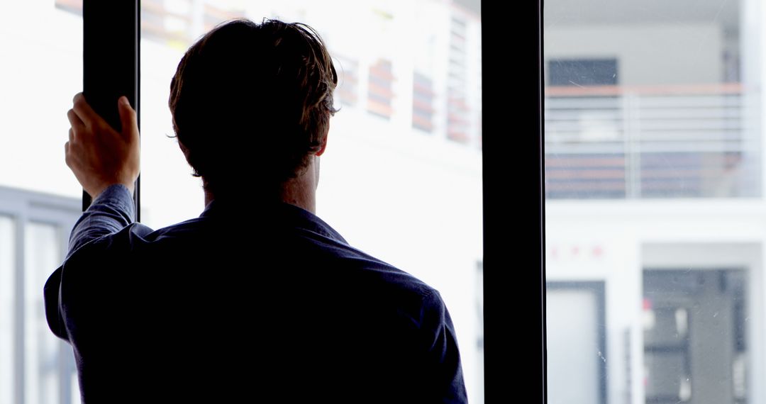 Man Looking Through Large Window at Modern Indoor Space - Free Images, Stock Photos and Pictures on Pikwizard.com