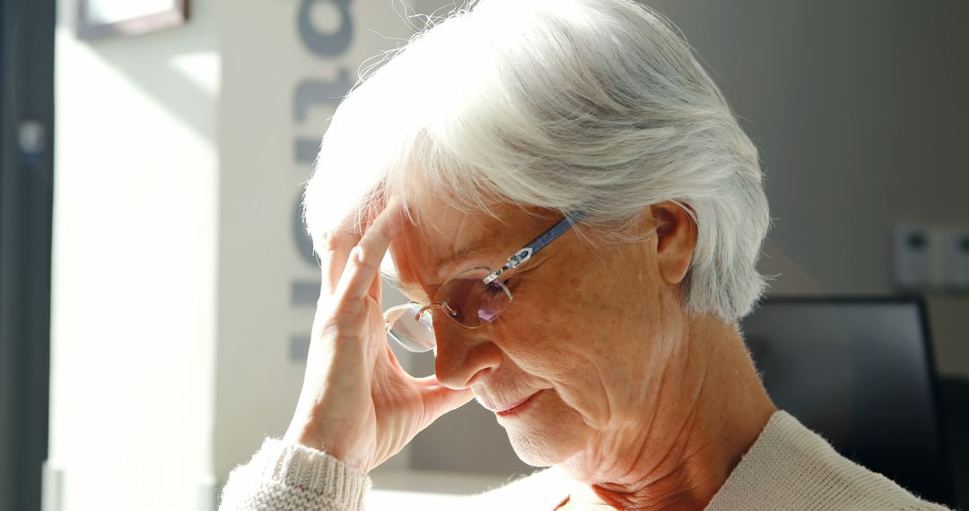 Senior Woman Experiencing Headache While Sitting Indoors - Free Images, Stock Photos and Pictures on Pikwizard.com