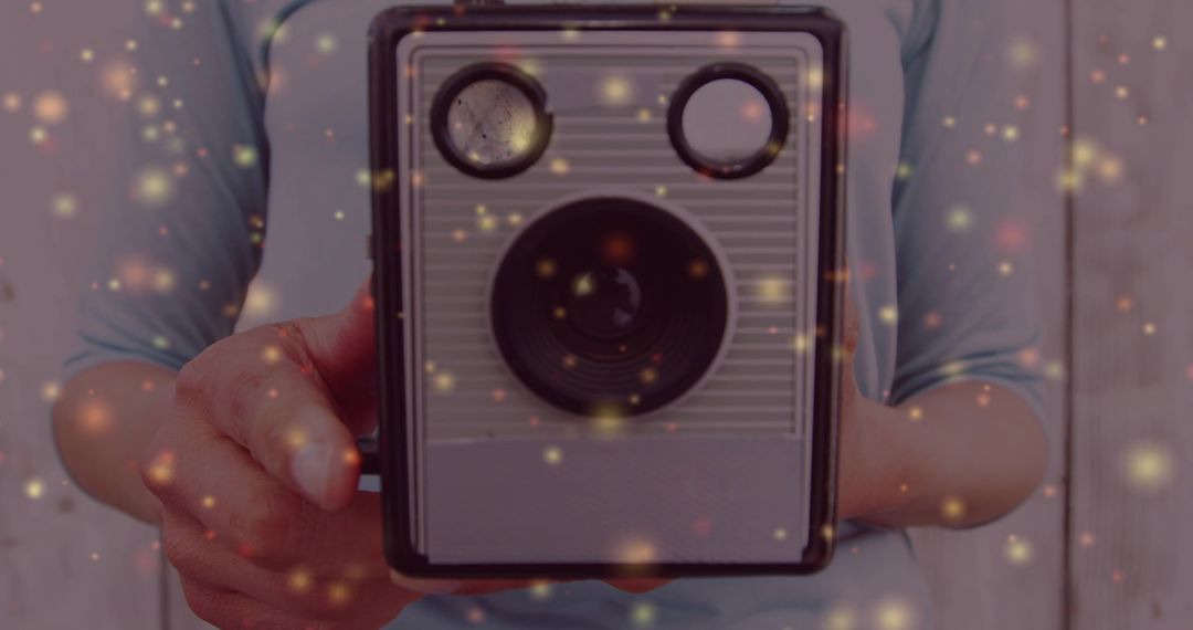 Woman holding vintage twin-lens camera with whimsical light flutter