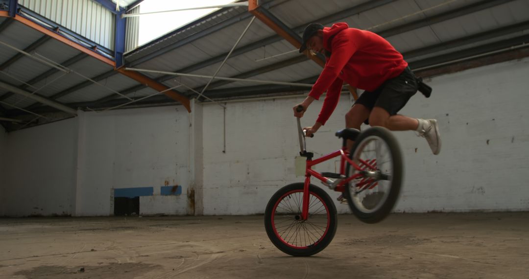 Man performing BMX tricks in deserted warehouse - Free Images, Stock Photos and Pictures on Pikwizard.com