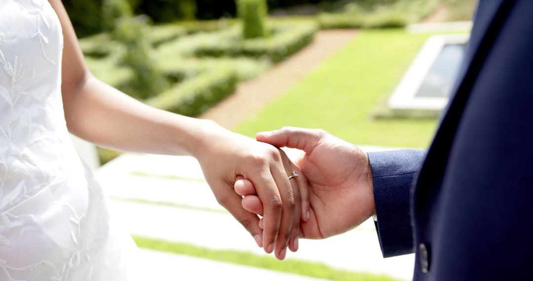 Bride and Groom Holding Hands Outdoors in Sunny Garden - Free Images, Stock Photos and Pictures on Pikwizard.com