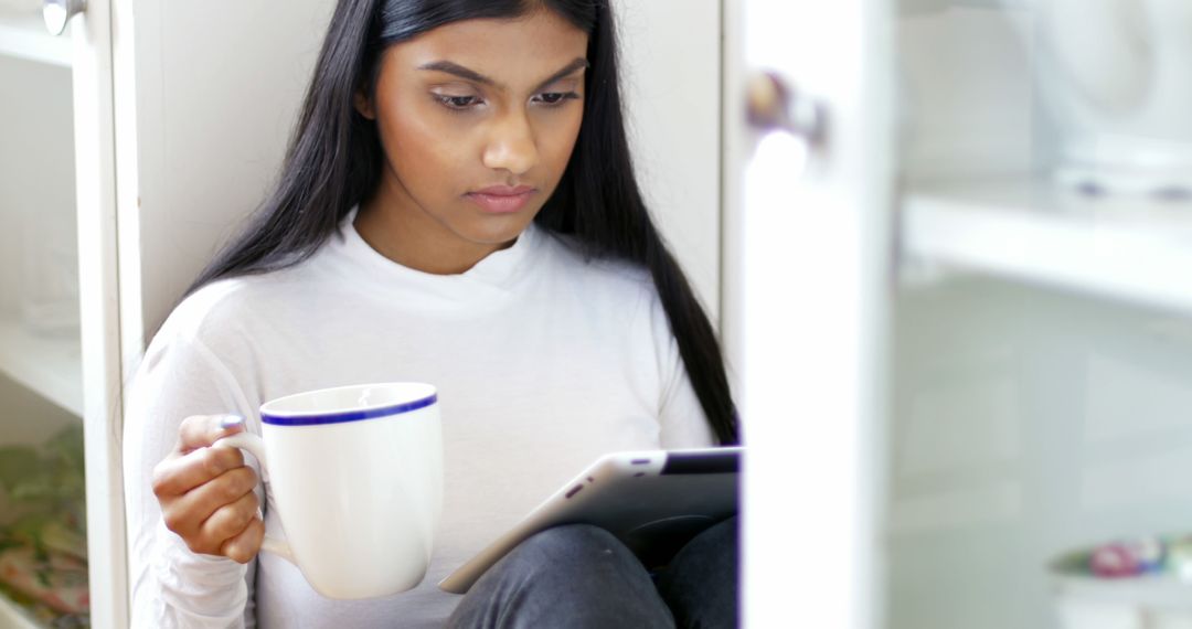 Young Woman with Tablet and Coffee Seated at Home - Free Images, Stock Photos and Pictures on Pikwizard.com