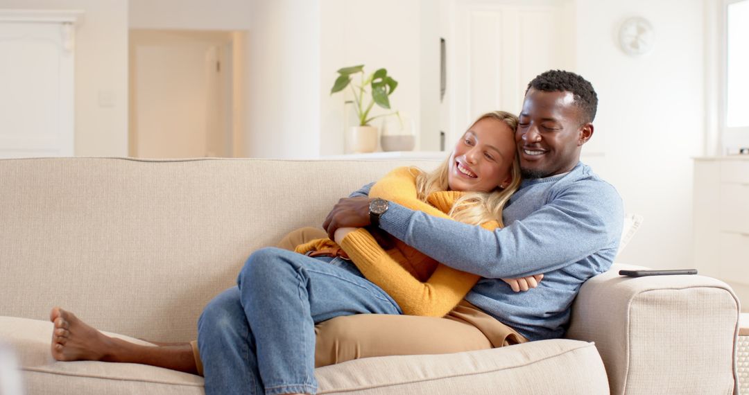 Happy Interracial Couple Embracing on Sofa Relaxing Together