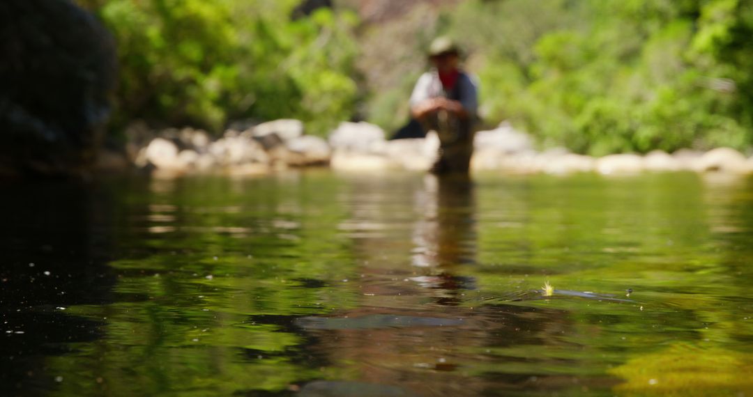 Blurred Fisherman in Nature Standing in Shallow Stream - Free Images, Stock Photos and Pictures on Pikwizard.com