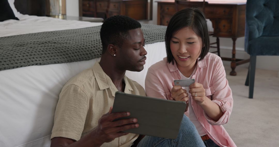 Diverse Couple Relaxing: Tablet Browsing and Knitting at Home