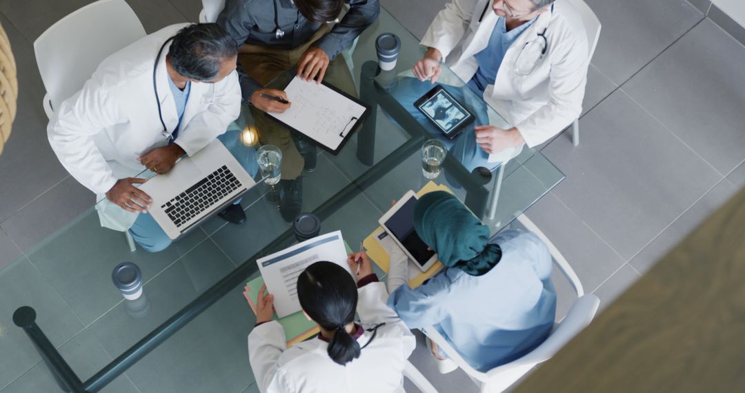 Medical Team Collaborating at Modern Office Table with Technology and Documents - Free Images, Stock Photos and Pictures on Pikwizard.com