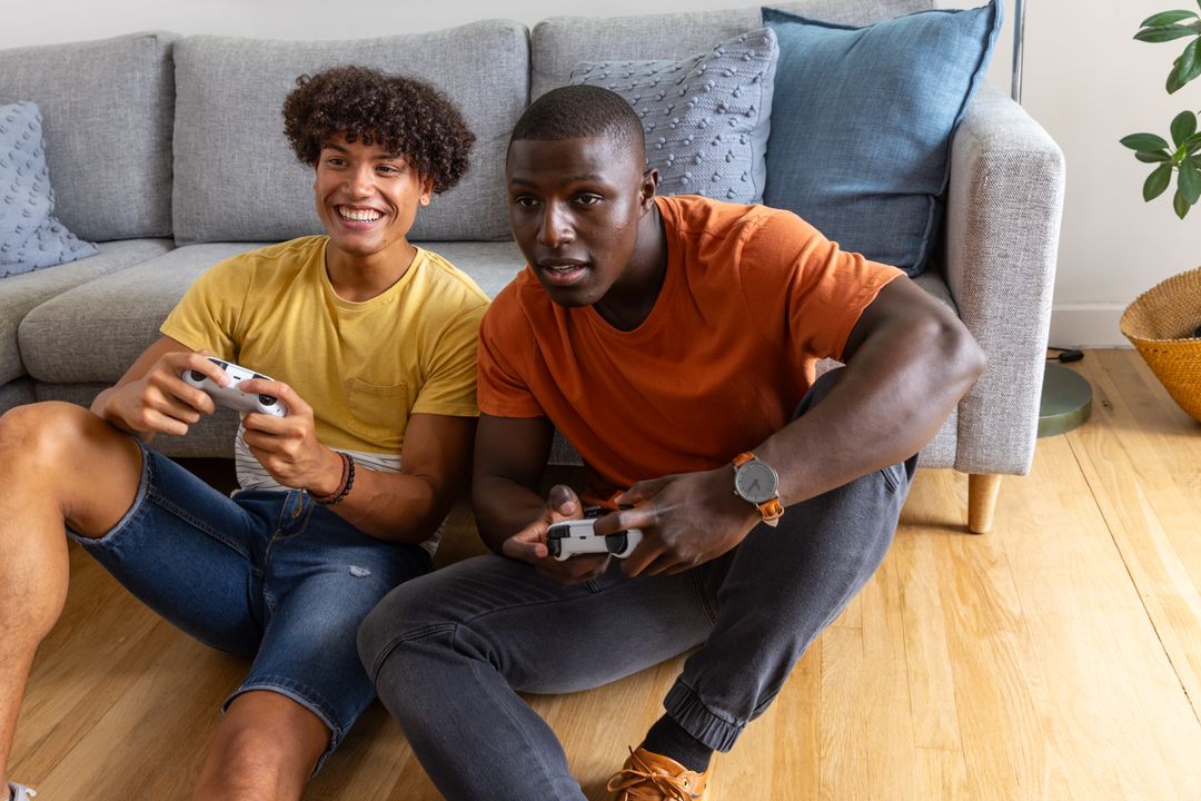 Young Friends Playing Console Games on Living Room Floor Laughing and Competing