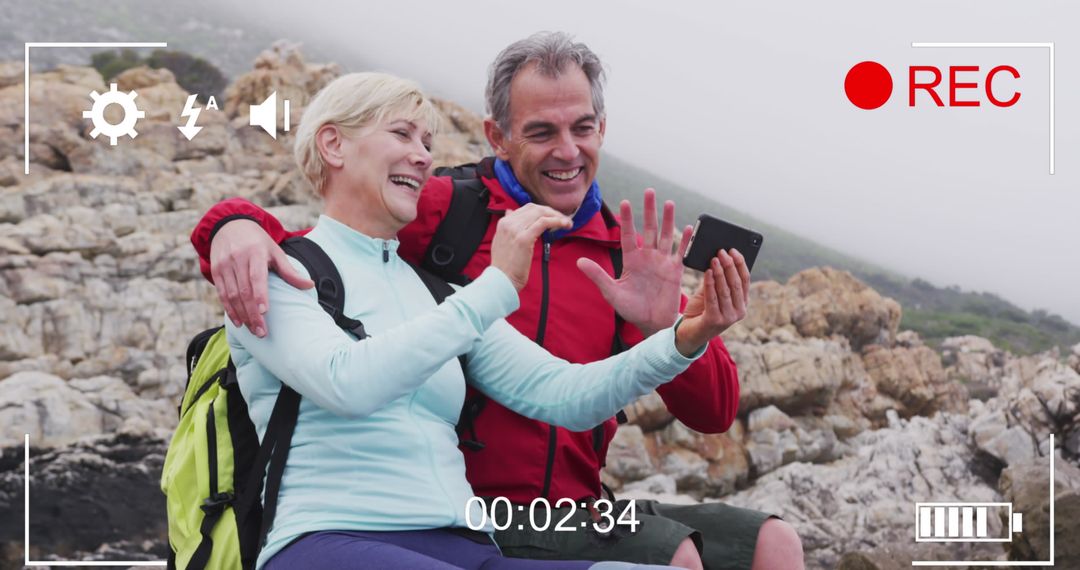 Senior Couple Embracing While Filming Beach Selfie with Smartphone