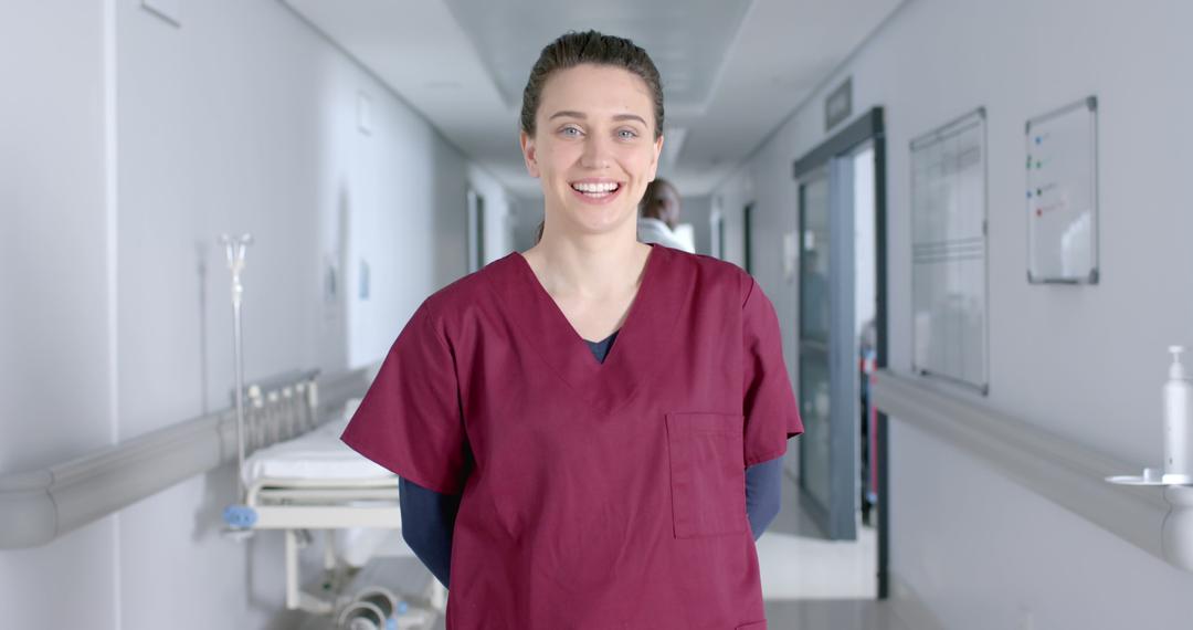 Smiling Healthcare Worker in Scrubs in Hospital Hallway - Free Images, Stock Photos and Pictures on Pikwizard.com