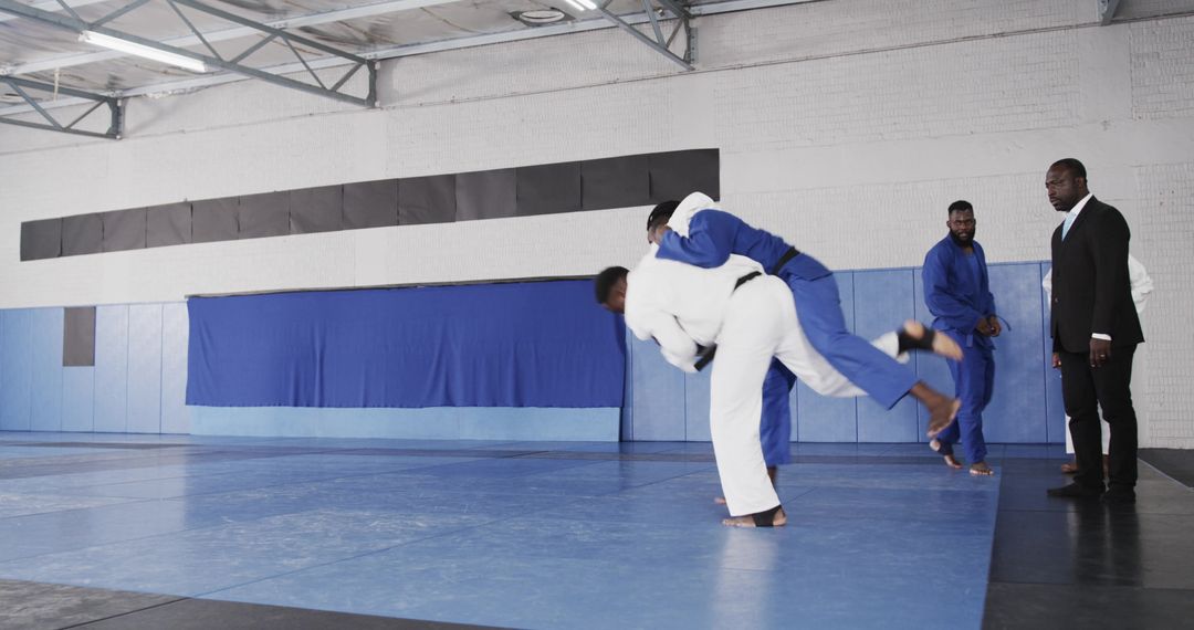 Martial Artists Performing Judo Throw in Training Hall