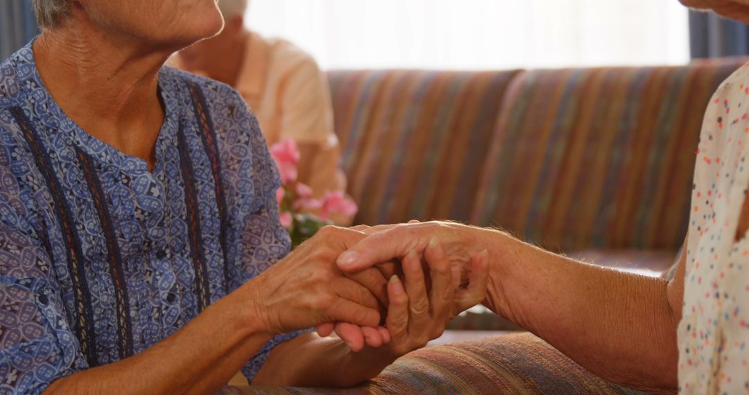 Elderly People Holding Hands and Offering Comfort in Care Facility - Free Images, Stock Photos and Pictures on Pikwizard.com