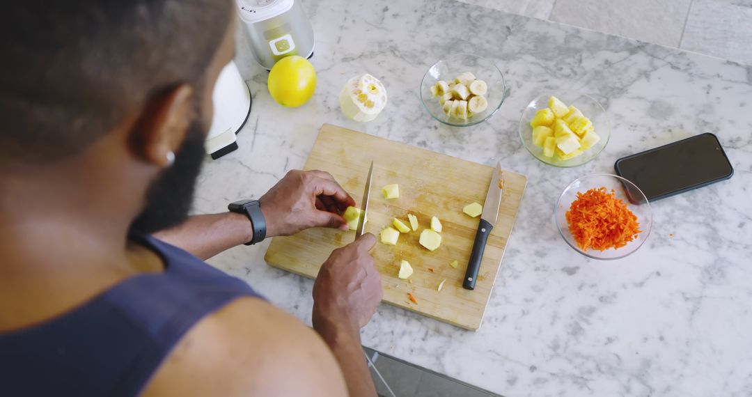 Man Chopping Fresh Fruit in Modern Kitchen for Nutritious Meal Prep