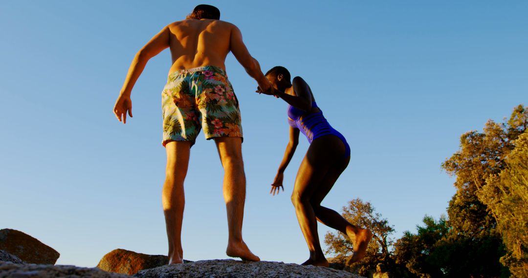 Couple Hiking on Rocky Cliff at Sunset - Free Images, Stock Photos and Pictures on Pikwizard.com