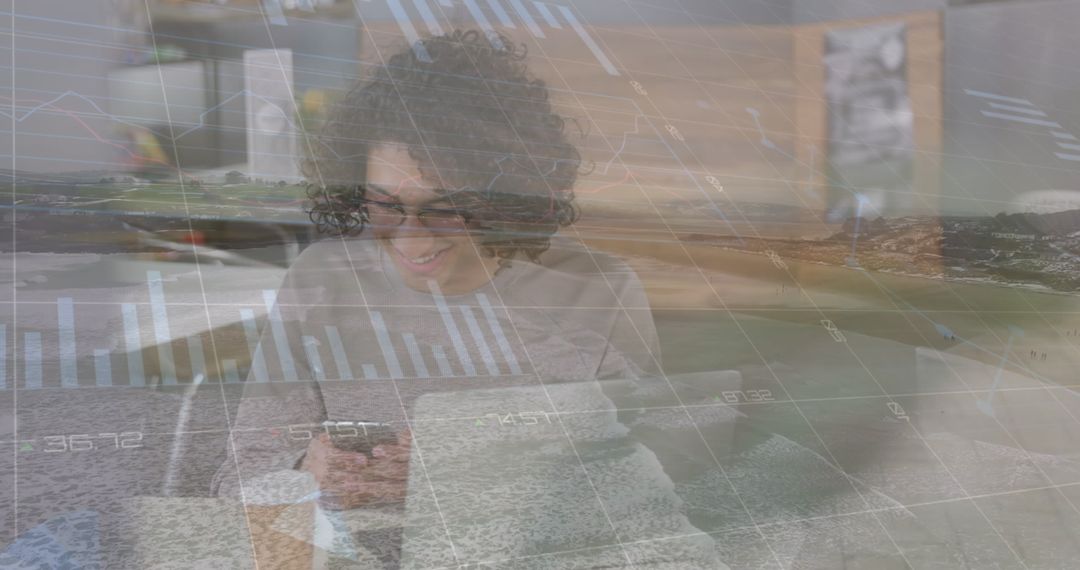 Smiling Man Engages with Smart Technology Amid Economic Analysis Graphics